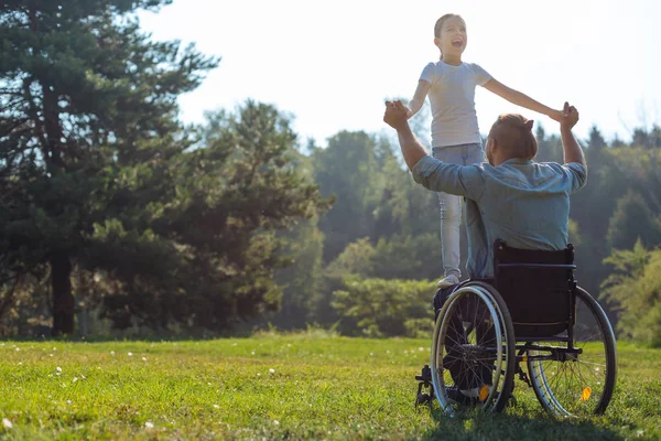 Un père handicapé tenant sa fille sur ses genoux — Photo