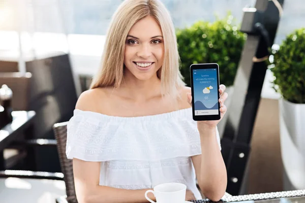 Glada blond kvinna visar du hennes smartphone — Stockfoto