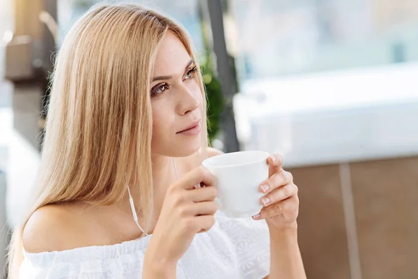 Продумана молода жінка п'є чай — стокове фото