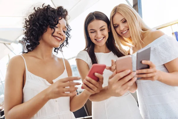 Mujer positiva feliz sosteniendo sus teléfonos inteligentes — Foto de Stock