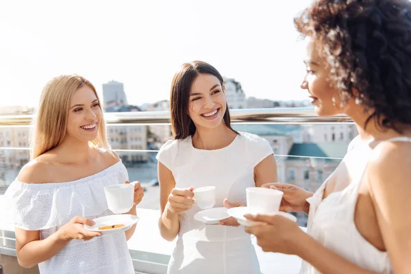 Mulheres alegres e atraentes tomando chá juntas — Fotografia de Stock