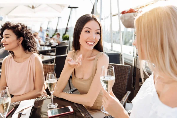 Neşeli çekici kadın arkadaşıyla konuşurken