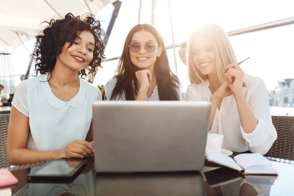 Joyful kvinnliga kolleger sitter framför den bärbara datorn — Stockfoto