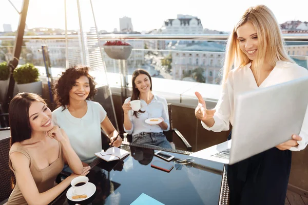 Bir dizüstü bilgisayar tutan çok mutlu mutlu kadın