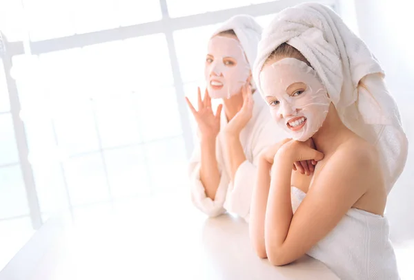 Mulheres positivas fazendo máscara facial — Fotografia de Stock