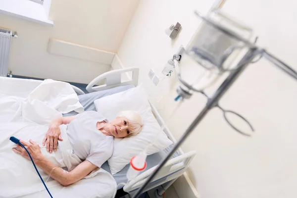 在医院的床上休息的痛病女人 — 图库照片