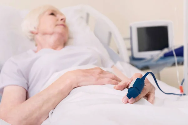 Mujer anciana enferma usando un dispositivo especial en su dedo — Foto de Stock
