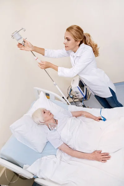 Begaan van opgeleide jonge dokter opzetten van een druppelaar — Stockfoto