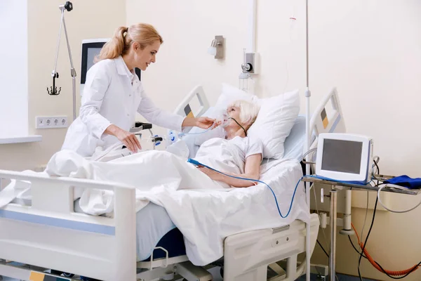 Encantadora doctora entrenada cuidando bien a su paciente — Foto de Stock