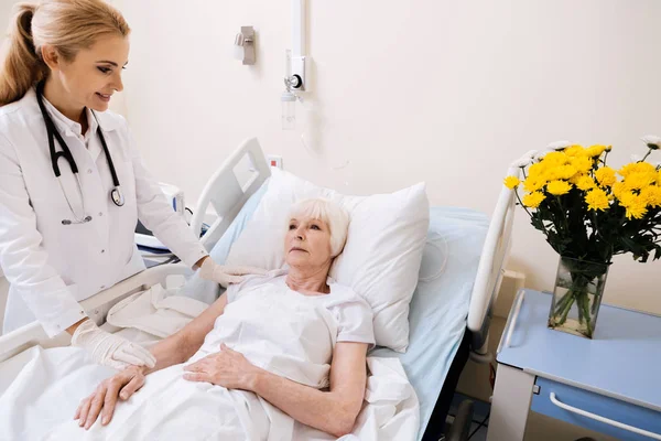 Doce médico delicado tentando animar seu paciente — Fotografia de Stock