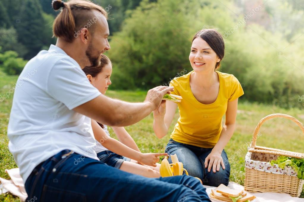 Pleasant young family sharing food on picnic — Stock Photo © Dmyrto_Z