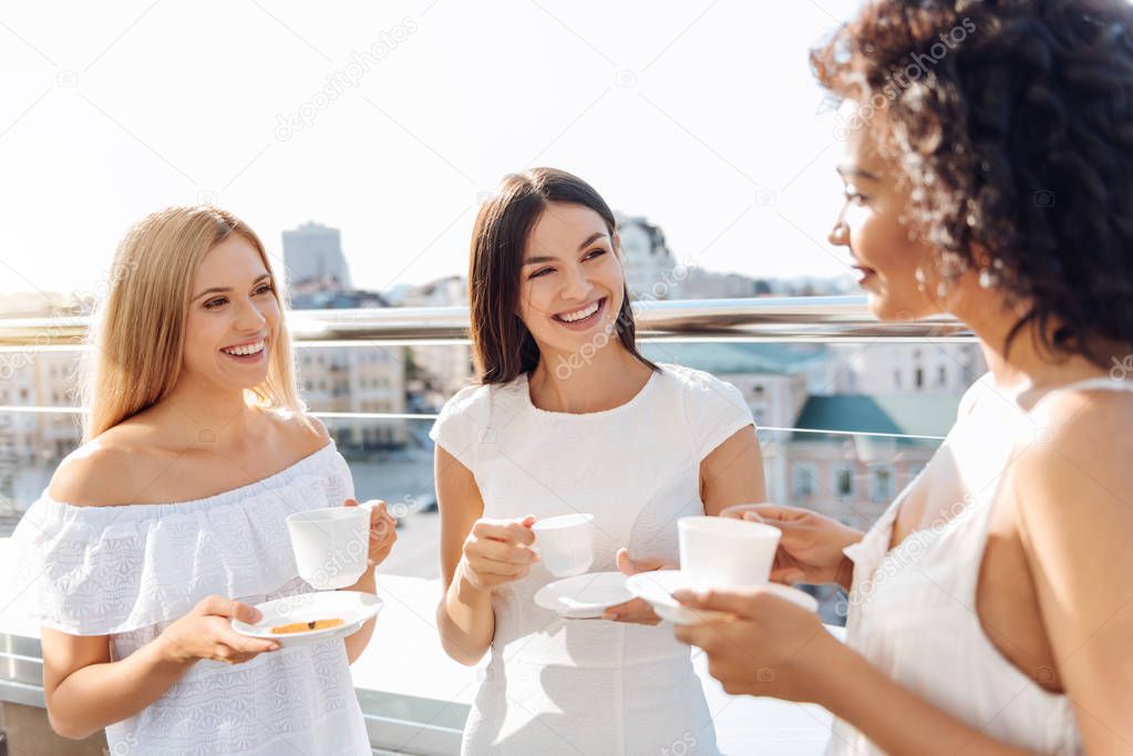 Cheerful attractive women having tea together