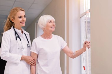 Özenli parlak doktor hastasını ile koridorda yürürken