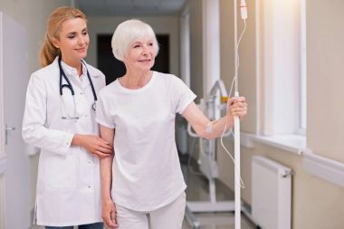 İyimser parlak doktor hastasını yürüyüşe alarak