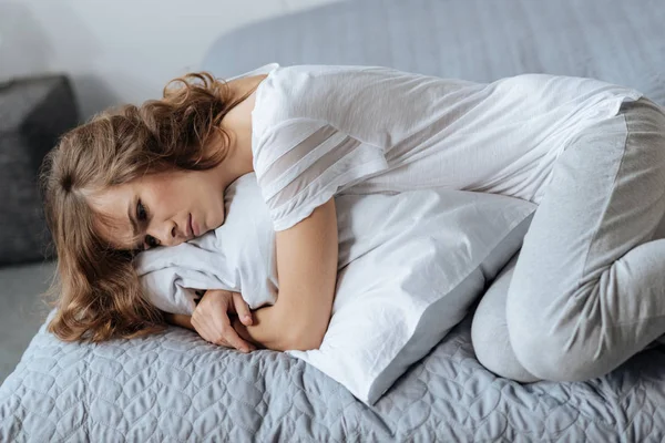 Грустная депрессивная женщина лежит на кровати — стоковое фото