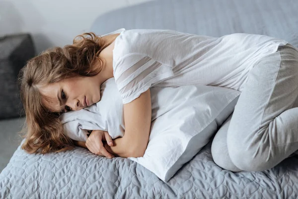 Sad depressed woman lying on the bed — Stock Photo, Image