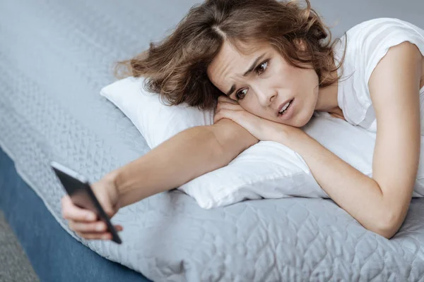 Unhappy surprised woman reading a message — Stock Photo, Image