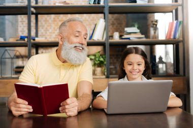 Onun granddaughters dizüstü bilgisayar ekranına bakarak keyifli komuta sizde