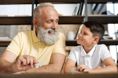 Dede ve torunu bulmaca yaparken gülümsüyor alışverişi