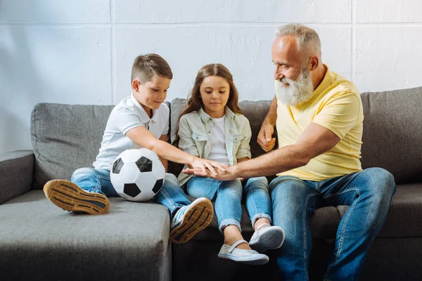 Pleasant boy putting hand on his grandfathers hand — Stock Photo, Image