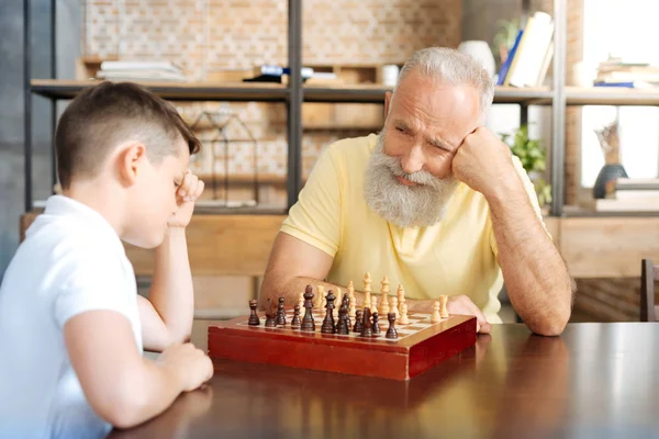 Grand-père en attente de ses petits-fils prochain mouvement dans le jeu d'échecs — Photo