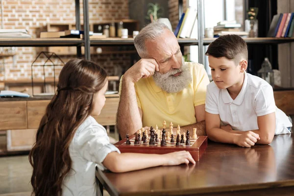 Abuelo dando a su nieto un consejo en el juego de ajedrez — Foto de Stock