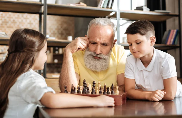 Abuelo y nieto planeando su próximo movimiento en el ajedrez — Foto de Stock