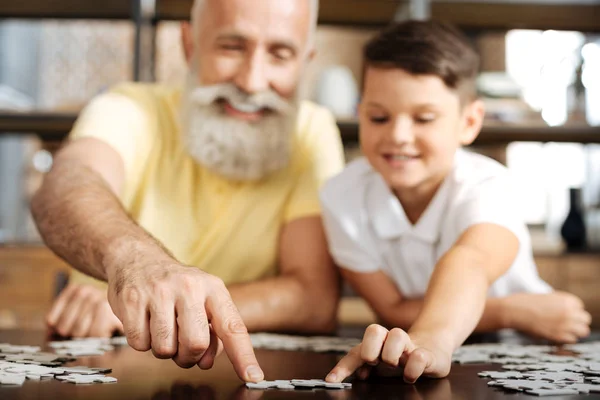 Grandfather and grandson connecting two pieces of jigsaw puzzle — Stock Photo, Image