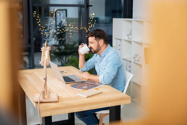 Agradable buen hombre sosteniendo una taza con té — Foto de Stock