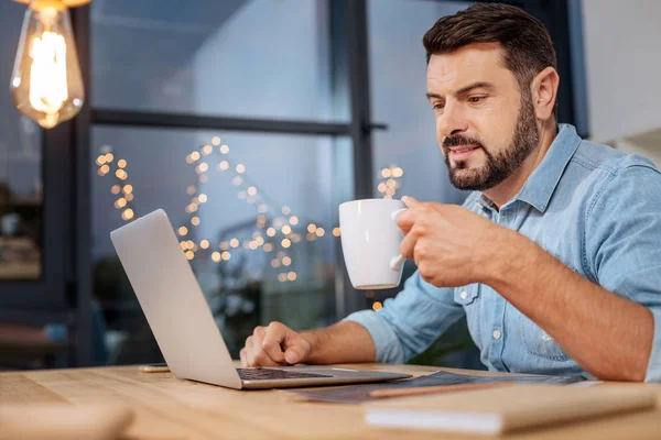 Agradable hombre trabajador disfrutando de su bebida — Foto de Stock