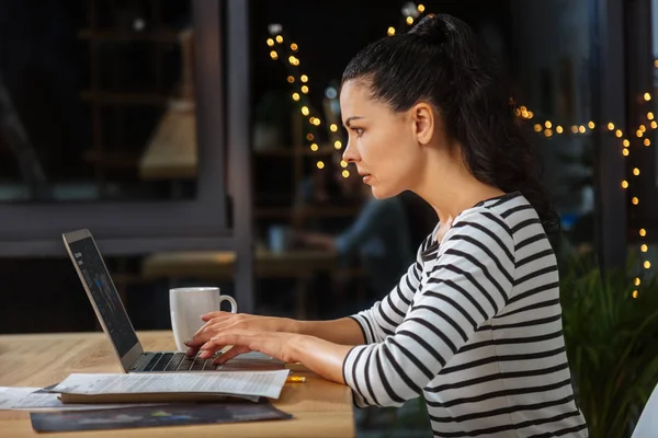 Ernsthaft hart arbeitende Frau, die sich auf ihre Arbeit konzentriert — Stockfoto