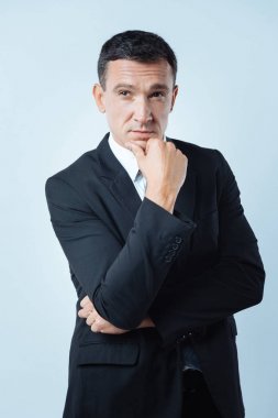 Düşünceli hoş adam çenesini tutarak