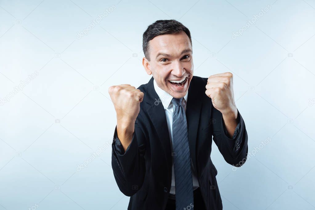 Happy cheerful man holding fists