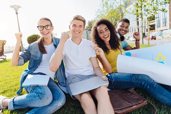 Glada studenter att göra nävar medan poserar på kamera — Stockfoto