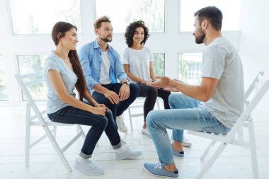 Onun grup önünde oturan yakışıklı güzel adam