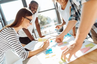 Neşeli genç meslektaşları gelecekteki çalışmalarını planlama
