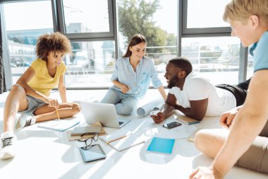 Katta oturan neşeli genç öğrenciler