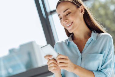 Akıllı telefonuna bir mesaj yazarak neşeli güzel kadın