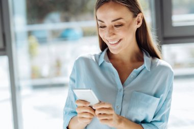 Onun smartphone kullanarak pozitif güzel iş kadını
