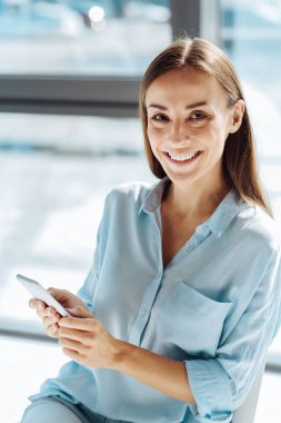 Onun akıllı telefon kullanan olumlu genç kadın