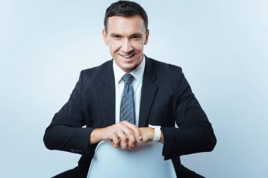 Sandalyede oturan yakışıklı neşeli adam