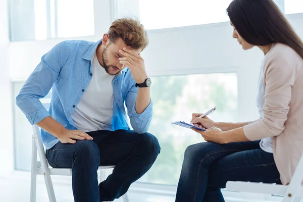 Desdichado hombre considerado sosteniendo su cabeza — Foto de Stock