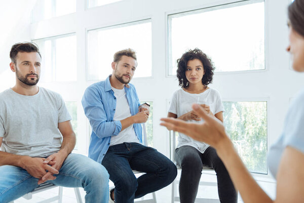 Серьёзные члены группы приятной терапии слушают своего друга
