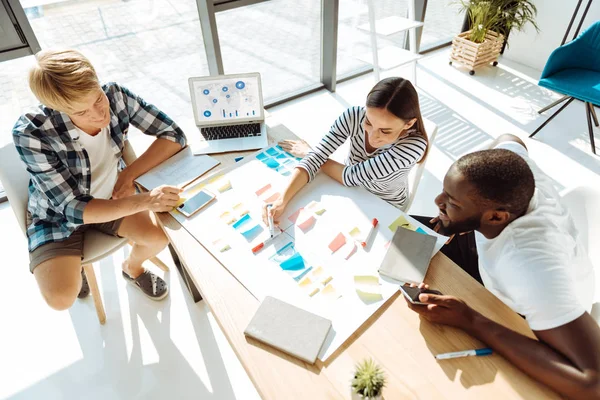 Vista dall'alto dei giovani positivi che lavorano su un progetto — Foto Stock