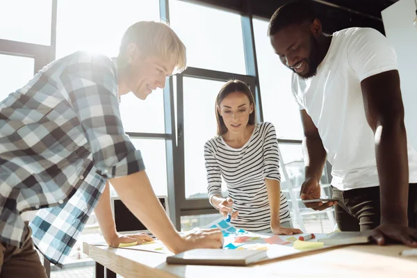 Fröhliche internationale Kollegen, die gemeinsam an dem Projekt arbeiten — Stockfoto