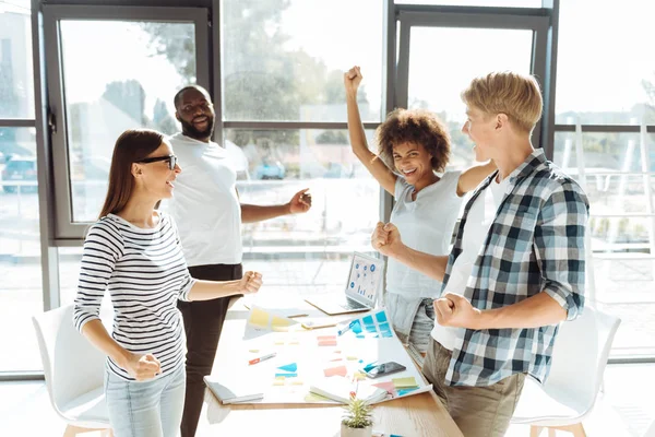 Fröhliche junge Kollegen feiern ein erfolgreiches Projekt — Stockfoto