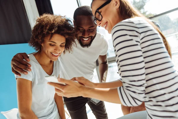 Vrolijke internationale studenten aan slimme telefoon — Stockfoto