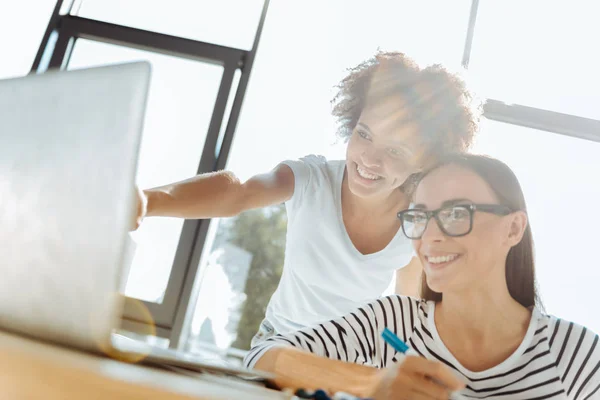 Alegre amigos femeninos usando el ordenador portátil juntos —  Fotos de Stock