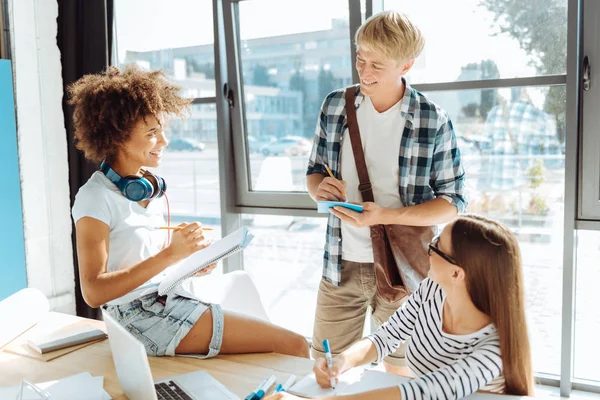 Jóvenes estudiantes positivos tomando notas — Foto de Stock