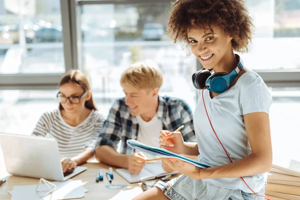 Lachende afro Amerikaanse jonge vrouw maken van notities — Stockfoto